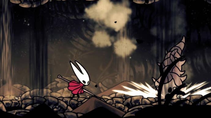 Hornet in Hollow Knight: Silksong makes her way across the rocky ground of the Wormways, evading the paths of burrowing worms falling from the ceiling.