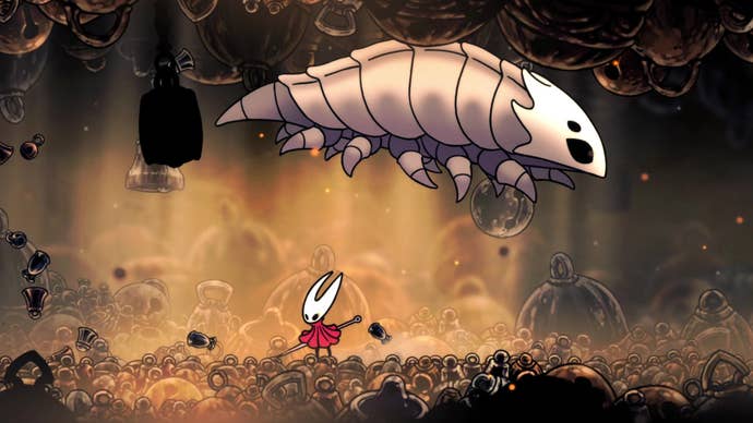 Hornet in Hollow Knight: Silksong battles a giant white insect known as the Bell Beast in a cave filled with bells.